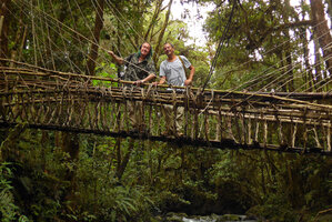 Patrick Blanc and Pascal Héni crossing a forest stream on a traditional wooden and rattan bridge, Tari, 2000 m asl, Hela, Papua New Guinea, March 2016