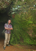 Patrick Blanc at a cave entrance, the vertical limestone walls being covered by green iridescent Hepatics and Mosses, Dieng, Wonosobo, Java, May 2018