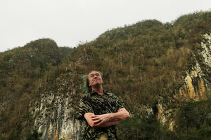 Patrick Blanc at the base of mogotes with the swollen stipes of the palm Gaussia princeps on vertical limestone cliffs, Valle de Vinales, Cuba, Feb. 2017.jpeg