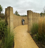 Patrick Blanc between the earth walls of the Ang garden by Vincent Dumay et al. at the garden festival, Chaumont-sur-Loire, France, Sept. 2021