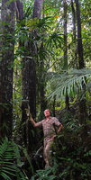 Patrick Blanc holding the trunk of the monocaulous Osmoxylon eminens with a terminal crown of digitate leaves, Balinsasayao Twin Lakes, Negros Oriental, Philippines, Jan. 2025