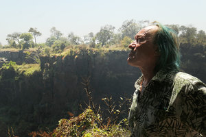 Patrick Blanc in front of a cliff covered by the red flowering Aloe chabaudii, Victoria Falls, Zimbabwe, Sept. 2017