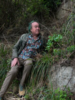 Patrick Blanc looking at Aster spathulifolius on vertical rock cliff, Igidae, Busan, South Korea, April 2026