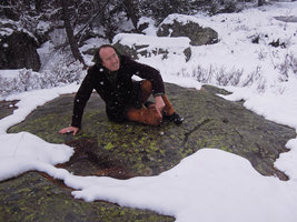 Patrick Blanc on a rock covered by lichens while snowing, Grisons, Switzerland, May 2016