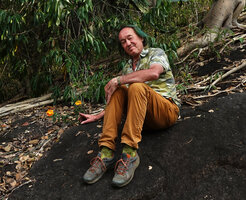 Patrick Blanc on a rock slab, close to the bright orange Crossandra infundibuliformis, Chinnar WS, Kerala, India, Jan. 2023