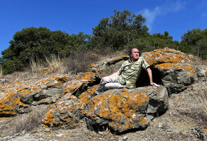 Patrick Blanc on rock covered by orange lichens on the Black Sea shore, Uzunya beach, Istanbul, Sept. 2021