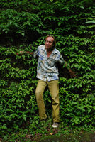 Patrick Blanc partly hidden by Pilea kiotensis covering a vertical rock, Kyoto, Japan