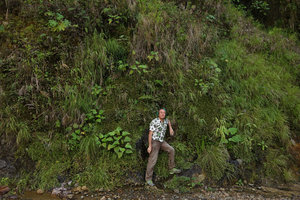 Patrick Blanc standing against a seeping natural vertical garden, Manu NP, 1500 m, Peru, Aug 2014