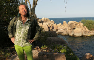 Patrick Blanc standing on rocks along the lake shore, Mumbo Island, Lake Malawi NP, Aug. 2017