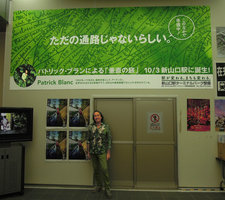 Patrick Blanc under the billboard announcement of the opening of the new walkway at the Shinkansen station, Yamaguchi, Japan, July 2015